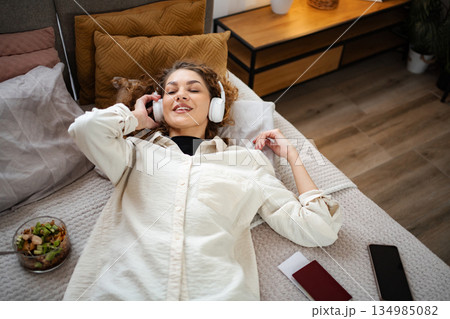 Woman relaxing in bed listening to music traveling 134985082