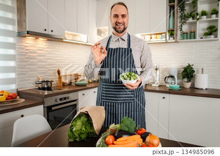 Man holding brussels sprouts giving ok gesture Man holding brussels sprouts giving ok gesture 134985096