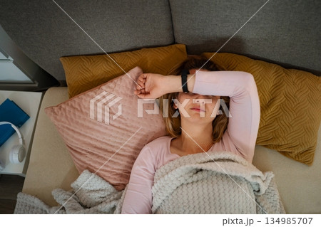 Tired woman resting on sofa experiencing headache 134985707