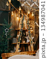 Decorated Christmas interior with glowing light bulbs and garland with evergreen pine branches and cones. Holiday decoration and festive mood. 134987041