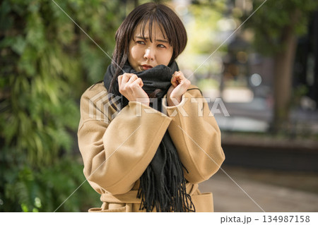 寒い冬にマフラーを巻いている女性 寒い冬にマフラーを巻いている女性 134987158