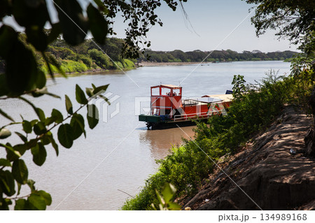 Non motorized ferry, called planchon, used by residents to cross the Sinu River from one bank to the other in the city of Monteria, Colombia. Non motorized ferry, called planchon, used by residents to cross the Sinu River from one bank to the other in the city of Monteria, Colombia. 134989168