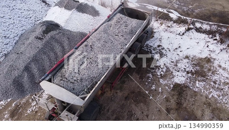 Aerial top view of a large truck unloading rubble on a construction site. Preparation for construction Aerial top view of a large truck unloading rubble on a construction site. Preparation for construction 134990359