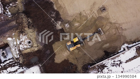An Industrial Excavator On An Open Road Section Loads Rock And Earth On A Very Large Dump Truck, Loaded With Ore .The Excavator Bucket Drips And Loads The Ore.Panorama Of Construction Works An Industrial Excavator On An Open Road Section Loads Rock And Earth On A Very Large Dump Truck, Loaded With Ore .The Excavator Bucket Drips And Loads The Ore.Panorama Of Construction Works 134990384