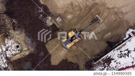 An Industrial Excavator On An Open Road Section Loads Rock And Earth On A Very Large Dump Truck, Loaded With Ore .The Excavator Bucket Drips And Loads The Ore.Panorama Of Construction Works An Industrial Excavator On An Open Road Section Loads Rock And Earth On A Very Large Dump Truck, Loaded With Ore .The Excavator Bucket Drips And Loads The Ore.Panorama Of Construction Works 134990385