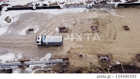 Aerial view of heavy machinery, Articulated truck moving dirt on a new road construction site, heavy equipment top down footage of dump truck. 134990393