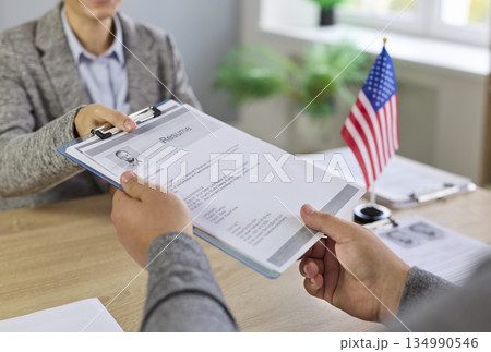 US visa and citizenship interview with officer reviewing applicant documents US visa and citizenship interview with officer reviewing applicant documents 134990546