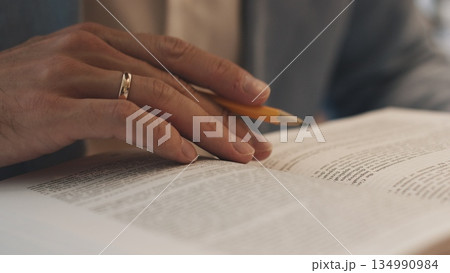 Unrecognizable lawyer's hand works with papers and law books in courtroom or office. Concept of justice and law, attorney or court judge. 134990984
