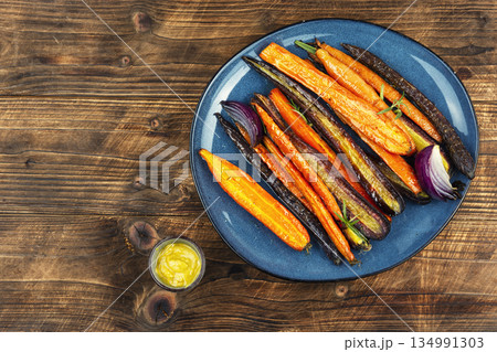 Delicious roasted baby carrots on wooden rustic background. 134991303