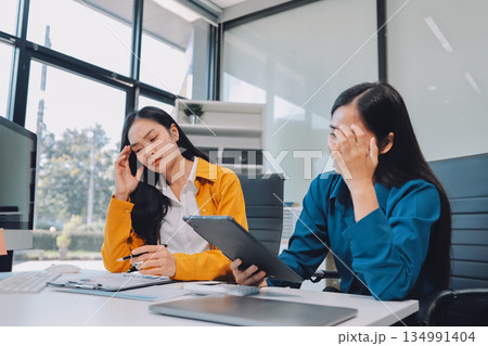 Asian women stressed at work. Teamwork in business with Older Asian women manager. Stressful deadline for young Asian women professional. 134991404