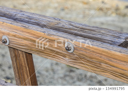Metal supports Bolts, nuts, threaded on beams of the wooden fence. Metal supports Bolts, nuts, threaded on beams of the wooden fence. 134991795