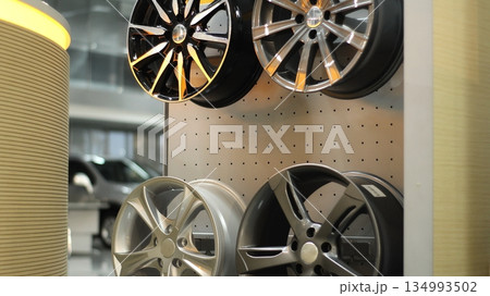 Alloy vehicle wheel disks on a wooden rack at car tuning showroom Alloy vehicle wheel disks on a wooden rack at car tuning showroom 134993502