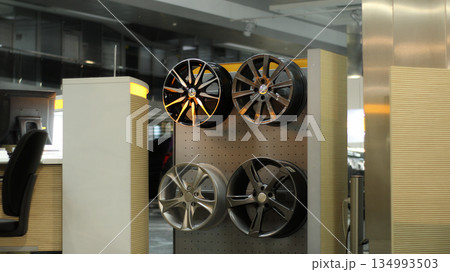 Aluminum alloy wheels on a wooden rack at car tuning showroom 134993503