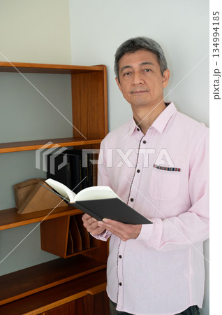 本棚の前で本を読む男性 本棚の前で本を読む男性 134994185