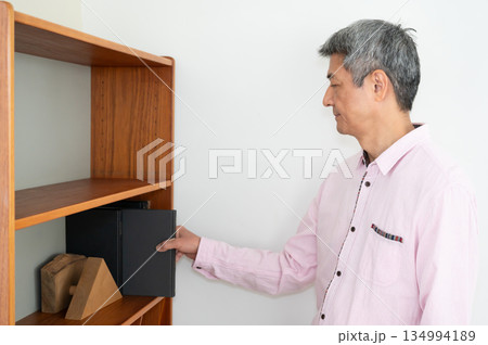 本棚から本をとる男性 134994189