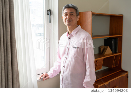 窓際に立つ男性 134994208
