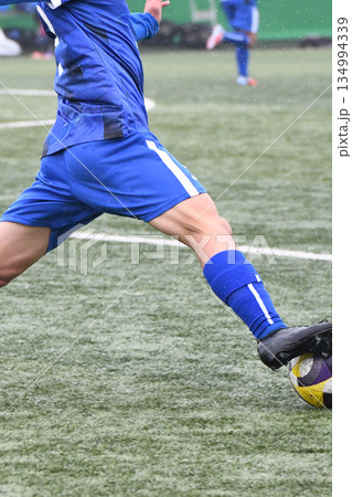 ドリブルするサッカー選手 134994339
