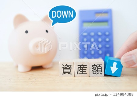 資産額ダウンを示す豚の貯金箱のイメージ。 134994399