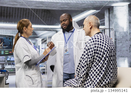 Two researchers testing a patient during a drug trial and recording side effects, monitoring dosage and studying allergic reactions. Biotechnology and clinical research for innovation. Two researchers testing a patient during a drug trial and recording side effects, monitoring dosage and studying allergic reactions. Biotechnology and clinical research for innovation. 134995141