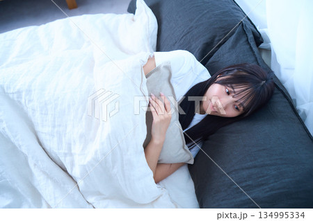 目を開けて横になっているシーン　若い女性 134995334
