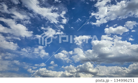 Vast blue sky filled with soft white clouds inspires calm, clarity, and a sense of freedom. Perfect for nature, travel, outdoor, wellness, and inspirational stock imagery. 134996251