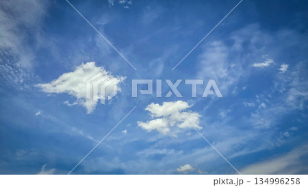 Vast blue sky filled with soft white clouds inspires calm, clarity, and a sense of freedom. Perfect for nature, travel, outdoor, wellness, and inspirational stock imagery. 134996258