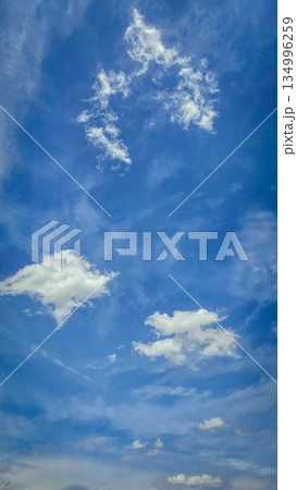 Vast blue sky filled with soft white clouds inspires calm, clarity, and a sense of freedom. Perfect for nature, travel, outdoor, wellness, and inspirational stock imagery. Vast blue sky filled with soft white clouds inspires calm, clarity, and a sense of freedom. Perfect for nature, travel, outdoor, wellness, and inspirational stock imagery. 134996259