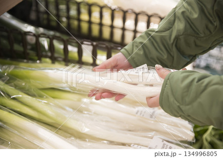 スーパーで長ねぎを手に取る女性買い物客手元 134996805