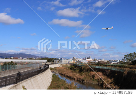 豊中市　千里川と着陸する飛行機 134997189