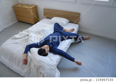 ベッドで眠る寝相が悪い男性 20代 ベッドで眠る寝相が悪い男性 20代 134997539