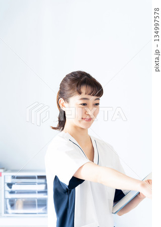 ファイルを持つ女性看護師 ファイルを持つ女性看護師 134997578