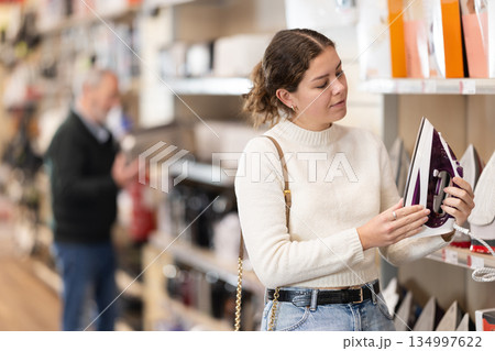 Woman choosing an iron in the store Woman choosing an iron in the store 134997622