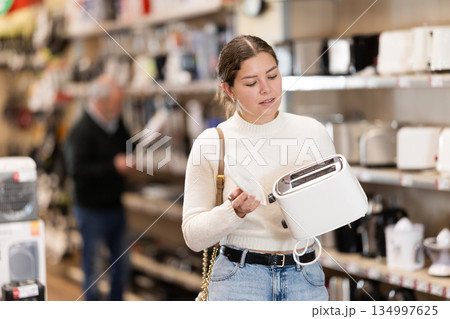 Young woman chooses toaster in appliance store 134997625
