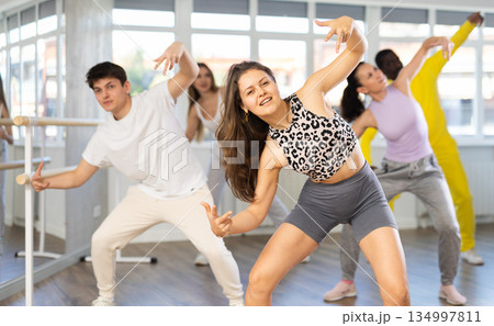 Woman and man in sportswear performing hip hop at group dance studio 134997811