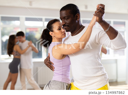 Woman with African man dancing waltz in couple during lesson at studio Woman with African man dancing waltz in couple during lesson at studio 134997862