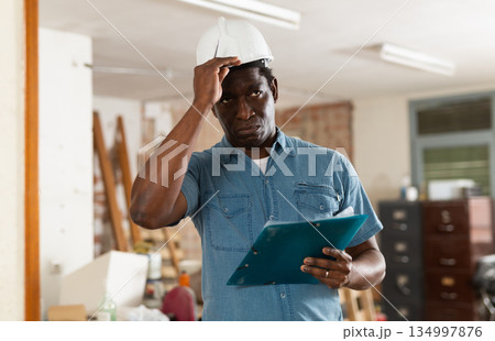 Male architect checking project documentation in apartment Male architect checking project documentation in apartment 134997876