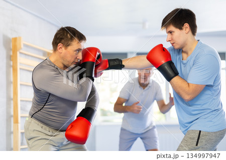 Two men training boxing fight in studio Two men training boxing fight in studio 134997947