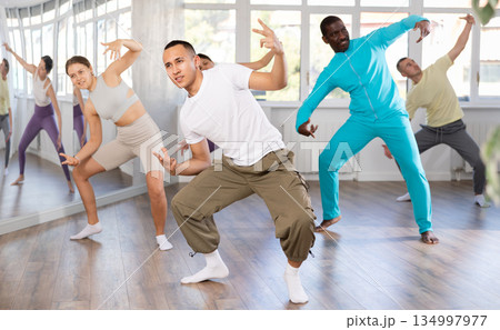 European guy with team of like-minded multinational people learn to elements of hip hop dance 134997977