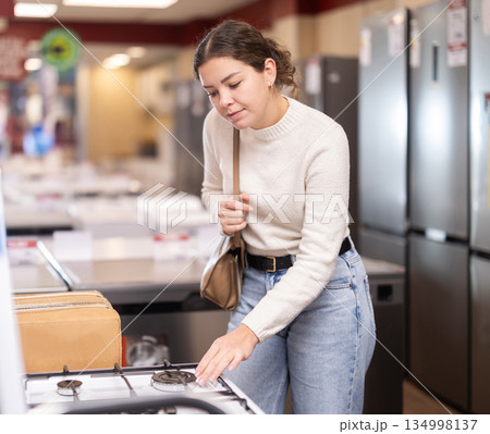 woman chooses a dishwasher and a washing machine in appliance store woman chooses a dishwasher and a washing machine in appliance store 134998137