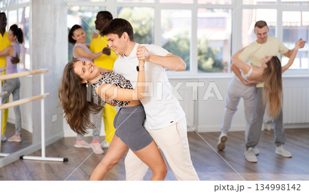 Man and young woman dancing waltz in couple during lesson at studio 134998142