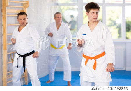 Young guy trains karate techniques in studio 134998228