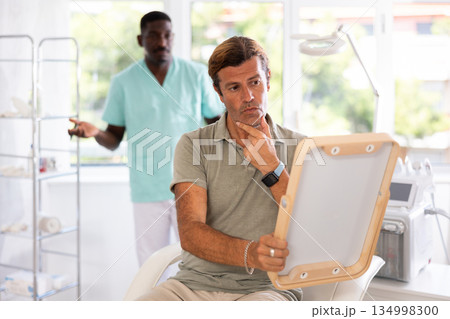 cosmetic physician confidently presents patient 134998300