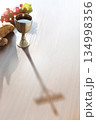 The bread and wine of the Eucharist and the inverted shadow of the cross symbolizing the suffering of Jesus Christ 134998356