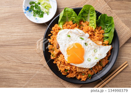 Korean kimchi fried rice with fried egg and spring onion on top 134998379
