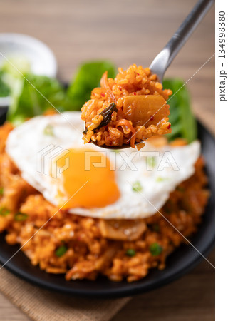 Korean kimchi fried rice with fried egg eating by spoon Korean kimchi fried rice with fried egg eating by spoon 134998380