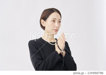 喪服を着た女性 拝む 白背景 喪服を着た女性 拝む 白背景 134998796