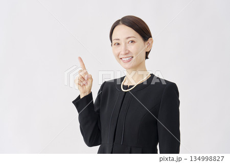 左を指差す喪服を着た女性 白背景 左を指差す喪服を着た女性 白背景 134998827