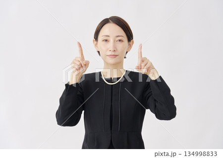 上を指差す喪服を着た女性 白背景 上を指差す喪服を着た女性 白背景 134998833