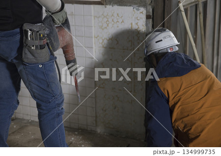電動ハツリ機でタオルを剥がそうとする作業員男性 134999735