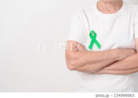 Elderly with Green Ribbon for concept of July Eye Injury Prevention month, January Glaucoma Awareness month, February Gallbladder and Bile duct and October Liver cancer. Health and world cancer day 134999863